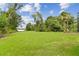 Expansive backyard featuring lush lawn and mature trees, ideal for outdoor activities and relaxation at 2103 N Golfview Dr, Plant City, FL 33566