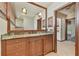 Bathroom featuring wooden vanity with granite countertop, a large mirror, and stylish sconces at 2103 N Golfview Dr, Plant City, FL 33566