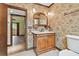 Traditional bathroom with a wooden vanity, decorative mirror, and wallpaper for an elegant touch at 2103 N Golfview Dr, Plant City, FL 33566