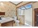 Well-lit bathroom featuring a glass shower with a skylight, floral wallpaper, and wood trim at 2103 N Golfview Dr, Plant City, FL 33566