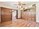 Spacious bedroom featuring wood floors, ceiling fan, and built-in wood cabinets at 2103 N Golfview Dr, Plant City, FL 33566