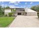 Stunning home featuring a stone facade, unique architectural details, and a welcoming brick driveway at 2103 N Golfview Dr, Plant City, FL 33566