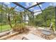 The screened pool deck with stone flooring features poolside lounge chairs and lush landscaping at 2103 N Golfview Dr, Plant City, FL 33566