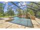 Screened pool with waterfall feature and stone surround evokes a luxurious, resort-like ambiance at 2103 N Golfview Dr, Plant City, FL 33566