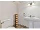Modern powder room boasting a pedestal sink, stylish sconces, and unique stone flooring for a luxurious feel at 2103 N Golfview Dr, Plant City, FL 33566