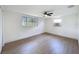 Bright bedroom features wood-look floors, updated windows, and a ceiling fan at 2115 Erin Dr, Holiday, FL 34690