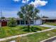 Well maintained home with a lush front yard and mature palm trees under a blue sky at 2115 Erin Dr, Holiday, FL 34690
