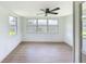 Bright sunroom features wood-look floors, white wainscoting, and multiple windows at 2115 Erin Dr, Holiday, FL 34690