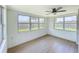 Bright sunroom features wood-look floors, white wainscoting, and multiple windows at 2115 Erin Dr, Holiday, FL 34690