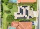 An overhead view of the house shows the solar panels and patio area, with surrounding trees and neighboring roofs at 2228 Hannah S Way, Dunedin, FL 34698