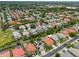 Aerial view of a residential neighborhood with lush green trees, colorful houses, and well-manicured lawns at 2228 Hannah S Way, Dunedin, FL 34698