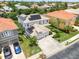 Property showcasing solar panels, a well-manicured lawn, mature trees, and a convenient three-car garage at 2228 Hannah S Way, Dunedin, FL 34698