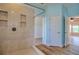 Light and airy bathroom showcasing a walk-in shower, a view to walk-in closet, and light hardwood flooring at 2228 Hannah S Way, Dunedin, FL 34698