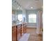 Bathroom featuring double sinks, wood cabinets, and a separate shower and tub with natural lighting at 2228 Hannah S Way, Dunedin, FL 34698