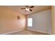 Cozy bedroom featuring a ceiling fan, light hardwood floors, and a window overlooking the front yard at 2228 Hannah S Way, Dunedin, FL 34698