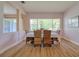 Sunlit dining room featuring wood floors, woven chairs, and a large window view at 2228 Hannah S Way, Dunedin, FL 34698