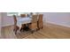 Close up shot of dining room table set with woven chairs and Persian style rug at 2228 Hannah S Way, Dunedin, FL 34698