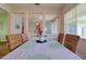 Bright dining room features wood floors, woven chairs, with hallway view at 2228 Hannah S Way, Dunedin, FL 34698