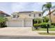 Charming two-story home featuring a three-car garage, well-maintained landscaping, and a mailbox at 2228 Hannah S Way, Dunedin, FL 34698