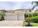 Inviting two-story home showcasing a three-car garage, well-maintained landscaping, and a neutral color palette at 2228 Hannah S Way, Dunedin, FL 34698