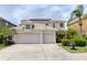 Beautiful two-story home with a three-car garage, solar panels, lush landscaping, and a well-maintained lawn at 2228 Hannah S Way, Dunedin, FL 34698