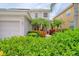 Charming home featuring lush landscaping, vibrant flowers, and a well-maintained front yard at 2228 Hannah S Way, Dunedin, FL 34698