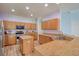 Bright kitchen features wood cabinets, an island, stainless steel appliances, and granite countertops at 2228 Hannah S Way, Dunedin, FL 34698