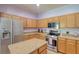 Spacious kitchen features stainless steel refrigerator, granite countertops, and wood cabinets at 2228 Hannah S Way, Dunedin, FL 34698