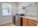 Modern laundry room with new front-loading washer and dryer and storage at 2228 Hannah S Way, Dunedin, FL 34698