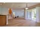 Open-concept living room features wood flooring, staircase, and sliding glass doors to the lanai at 2228 Hannah S Way, Dunedin, FL 34698