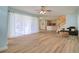 Bright living room features lots of space, a ceiling fan, and sliding glass doors to the outside patio at 2228 Hannah S Way, Dunedin, FL 34698