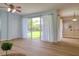 Bright living room features lots of space, a ceiling fan, and sliding glass doors to the outside patio at 2228 Hannah S Way, Dunedin, FL 34698