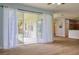 Bright living room features lots of space, a ceiling fan, and sliding glass doors to the outside patio at 2228 Hannah S Way, Dunedin, FL 34698