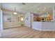 Open-concept living space with wood floors, light color walls, and kitchen view at 2228 Hannah S Way, Dunedin, FL 34698