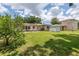 A spacious backyard with lush green grass, mature trees, and a storage shed at 2415 York N St, St Petersburg, FL 33710