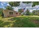 View of the home from under a large tree with American flag in the front yard at 2415 York N St, St Petersburg, FL 33710