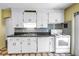 Well-lit kitchen featuring white appliances, ample cabinet space, and tile backsplash at 2415 York N St, St Petersburg, FL 33710