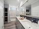 Bright bathroom featuring dual sinks, a large mirror, quartz countertops, a walk-in shower and storage at 246 Gretna St, Port Charlotte, FL 33954