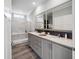 Bright bathroom featuring dual sinks, a large mirror, quartz countertops and a walk-in shower at 246 Gretna St, Port Charlotte, FL 33954