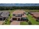 Aerial view of home showcasing tile roof, lush landscaping, and serene water views at 29038 Picana Ln, Wesley Chapel, FL 33543