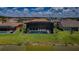 Aerial view showcasing a home with a screened pool and spacious backyard near a serene lake at 29038 Picana Ln, Wesley Chapel, FL 33543