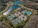Aerial view of tennis courts, community pool, parking, and lakes at 29038 Picana Ln, Wesley Chapel, FL 33543