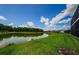 Scenic backyard with a serene pond and lush green lawn at 29038 Picana Ln, Wesley Chapel, FL 33543