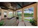 Covered lanai with screened enclosure overlooking a tranquil pond and lush landscaping at 29038 Picana Ln, Wesley Chapel, FL 33543