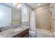Bathroom features a shower-tub combo, granite countertop, and ample lighting for a refreshing experience at 29038 Picana Ln, Wesley Chapel, FL 33543