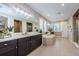 Bright bathroom boasts dual sinks, large mirror, soaking tub, plantation shutters, and tile flooring at 29038 Picana Ln, Wesley Chapel, FL 33543