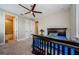 Cozy bedroom with a ceiling fan, carpet flooring, and an ensuite bathroom for added convenience at 29038 Picana Ln, Wesley Chapel, FL 33543