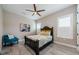 Cozy bedroom with a ceiling fan, wood-look tile floors, and shuttered windows at 29038 Picana Ln, Wesley Chapel, FL 33543