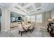 Elegant dining room with coffered ceiling, large windows, and stylish table setting, adjacent to a comfortable living area at 29038 Picana Ln, Wesley Chapel, FL 33543