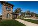 Grand entrance with stone architecture, arched windows, tile roof and lush landscaping in the Estancia at Wiregrass community at 29038 Picana Ln, Wesley Chapel, FL 33543